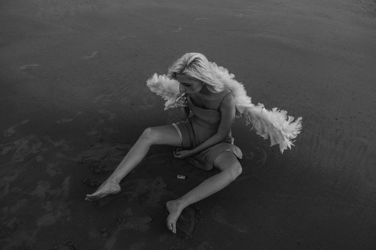Woman Sitting on Ground With Angel Wings