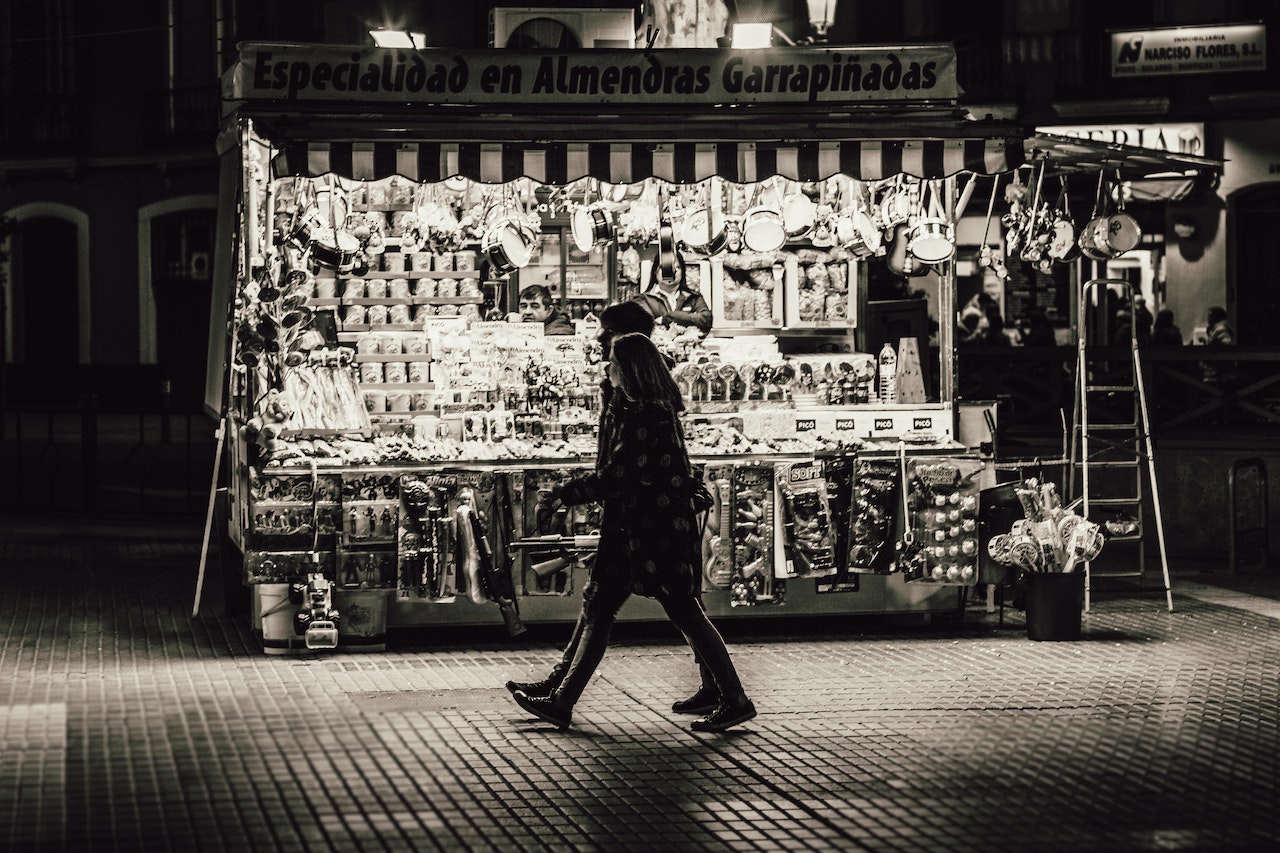 Man and Woman Walking in Front of Store