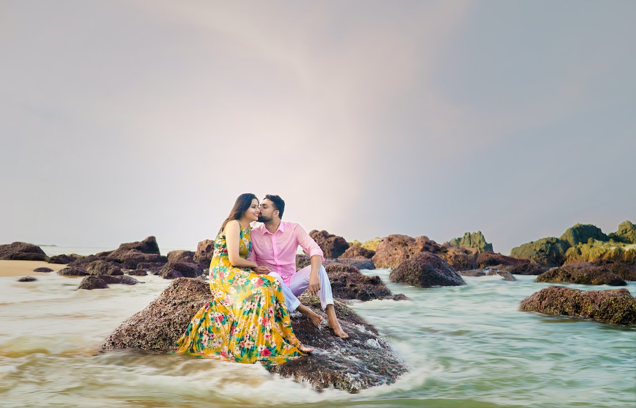 Couple sitting on a rock on the beach