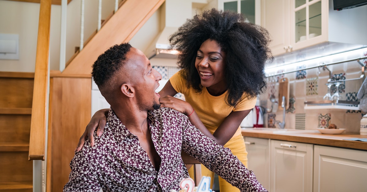Woman surprising her boyfriend in the kitchen