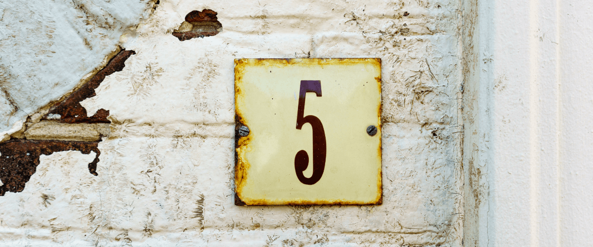 An old white wall with number 5 on it