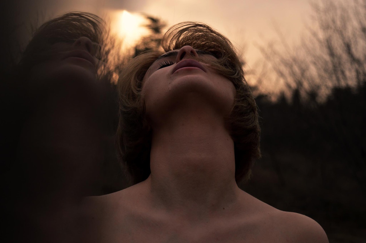 Man with bob hair cut looking up the sky with his neck exposed