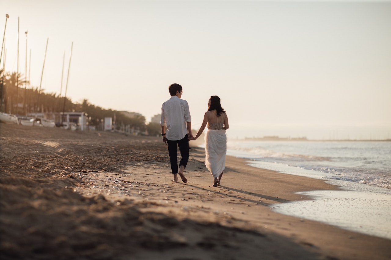 Back View of a Couple Walking on the Beach
