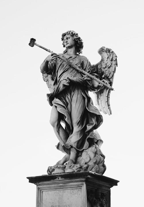 A statue of a winged-angel with a hammer like wand