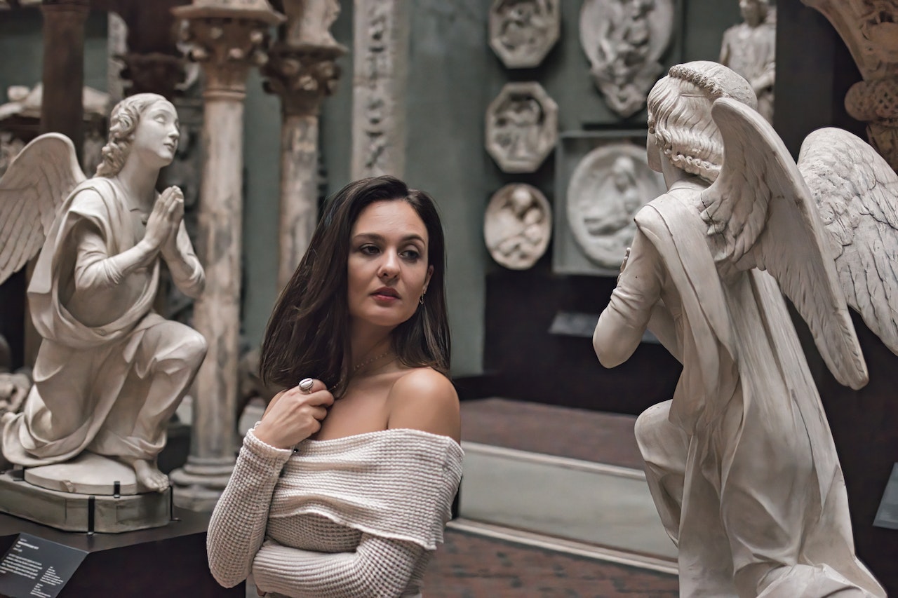 A Woman Standing Between Angel Statues