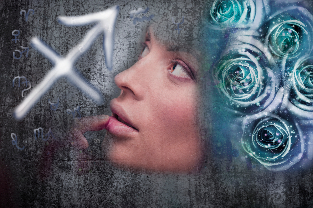 A woman looking at a Sagittarius zodiac sign.